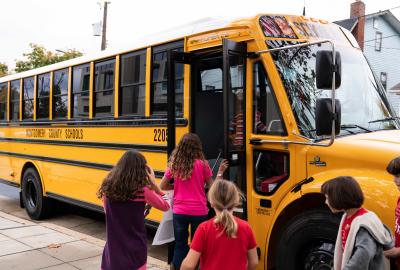 Children getting on an electric school bus