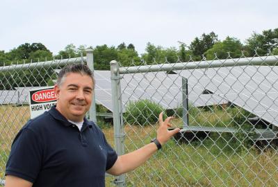 Mick Iskric standing in front of a solar array
