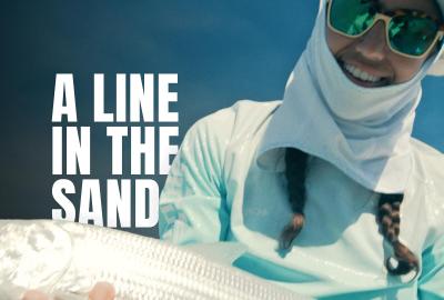 An angler fisher holding a fish with the words "A line in the sand" superimposed over his shoulder