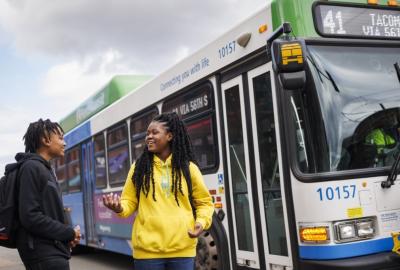Two people about to board a city bus