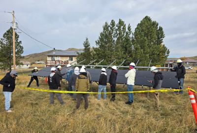 A group of people putting up a large solar panel