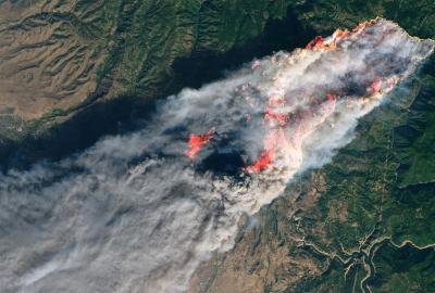 An aerial view of a spreading wildfire