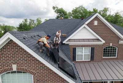 Workers installing solar panels on a rooftop