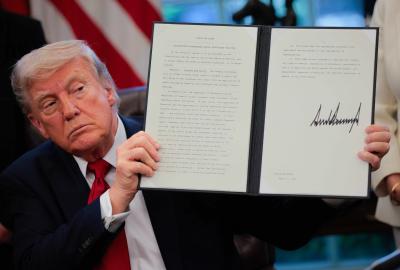 Donald Trump holding up an executive order he has signed