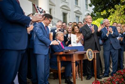 President Donald Trump signing the "big, beautiful bill" surrounded by members of Congress in front of the White House