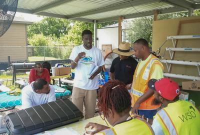 Small gathering of 6 Houston residents discussing OSHA safety training and solar installation