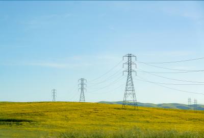 High tension lines cut across rolling hills near San Francisco, USA, weaving a modern energy network amidst the natural landscape.