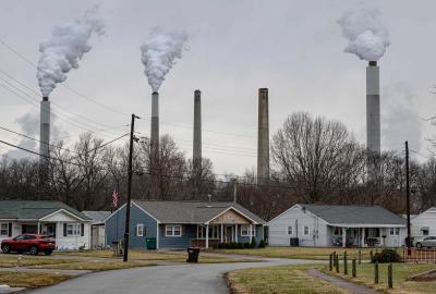 Residential homes in the foreground with smokestacks in the background