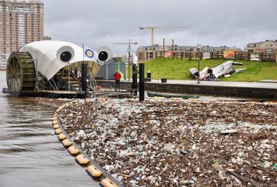 Mr. Trash Wheel, a large trash-eating contraption with googly eyes, about to eat some trash in Baltimore Harbor