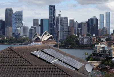 Solar panels on a rooftop with the Sydney Opera House in the background