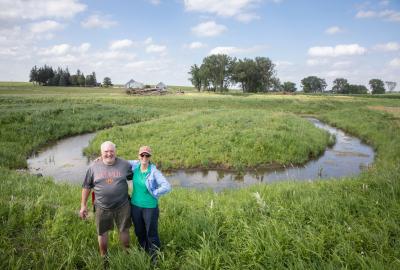 Brad Ohrt and Ruth McCabe stand in front of an oxbow wetland