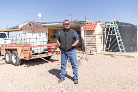 Luis Felipe Lujan standing in front of a water tank on the back of a truck