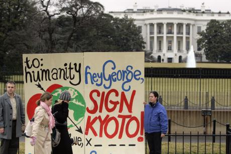 People holding a Valentine that reads "Hey George, Sign Kyoto" in front of the White House