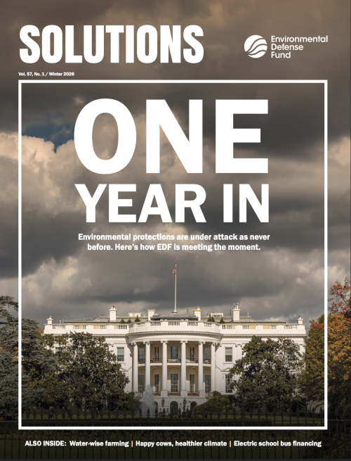 The Solutions magazine cover titled One Year In with the White House with storm clouds over it in the background