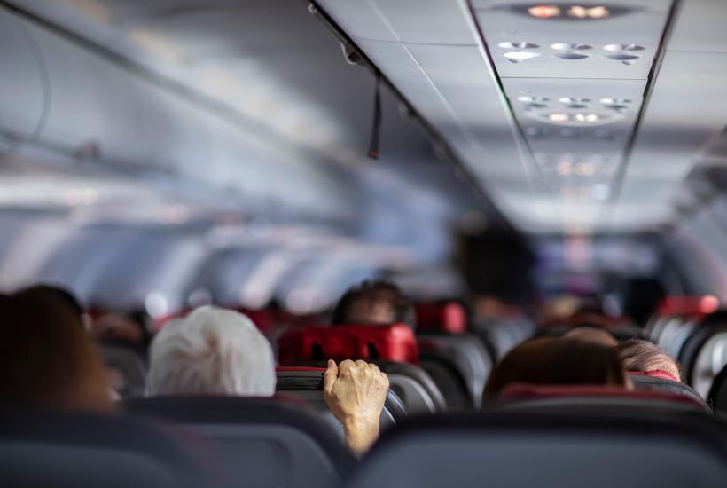 A person gripping a plane seat tightly