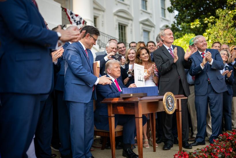 President Donald Trump signing the "big, beautiful bill" surrounded by members of Congress in front of the White House
