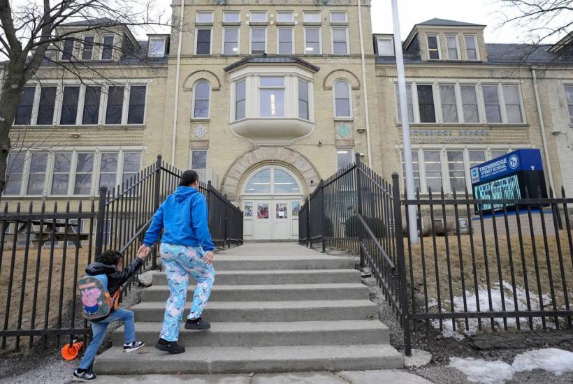 A parent and child walking up to the Trowbridge Street School of Great Lakes Studies in Milwaukee