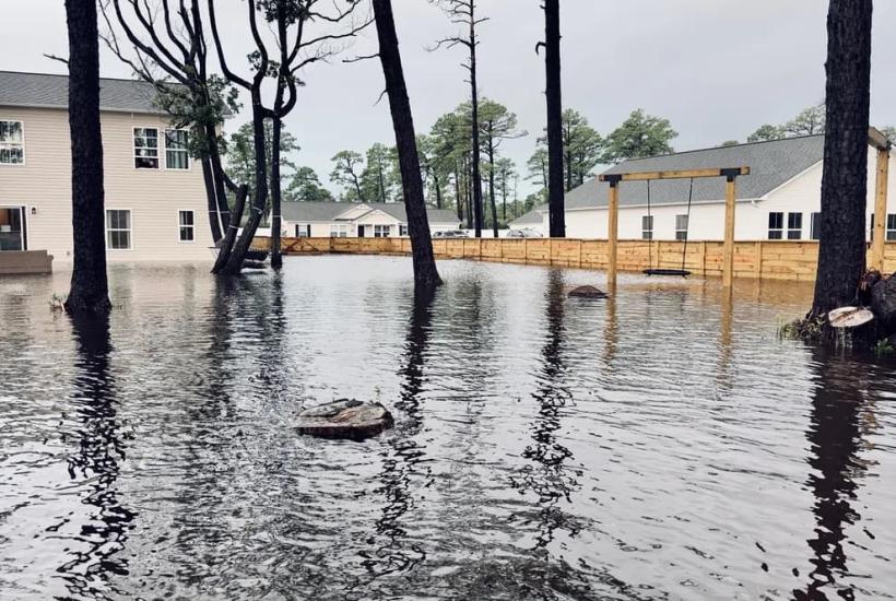 Flood waters encroaching on houses through their backyards
