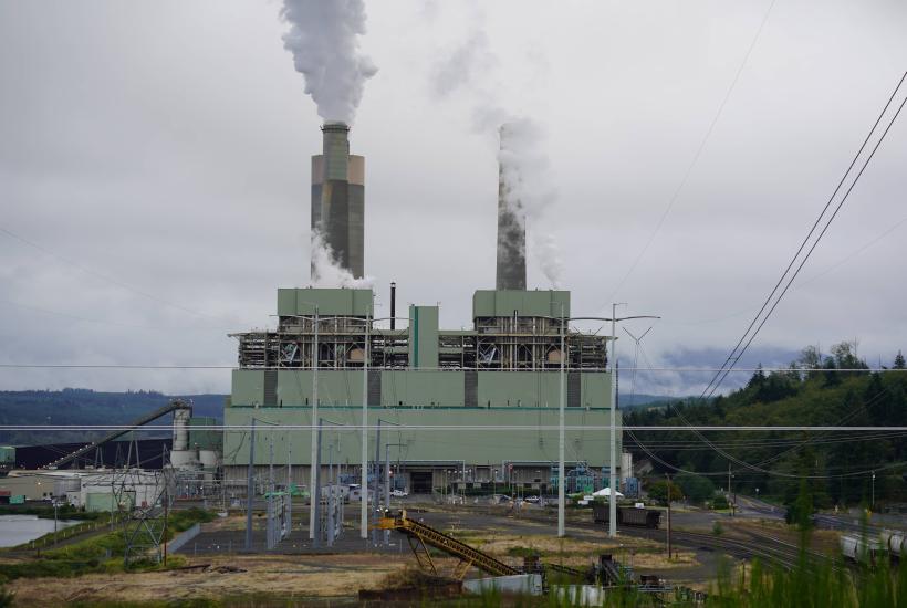 A coal power plant with smoke coming out of its smokestacks 