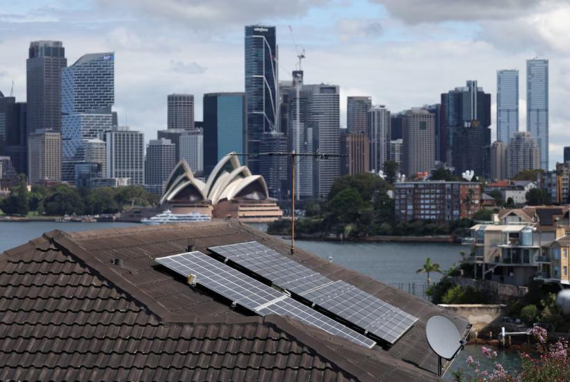 Solar panels on a rooftop with the Sydney Opera House in the background